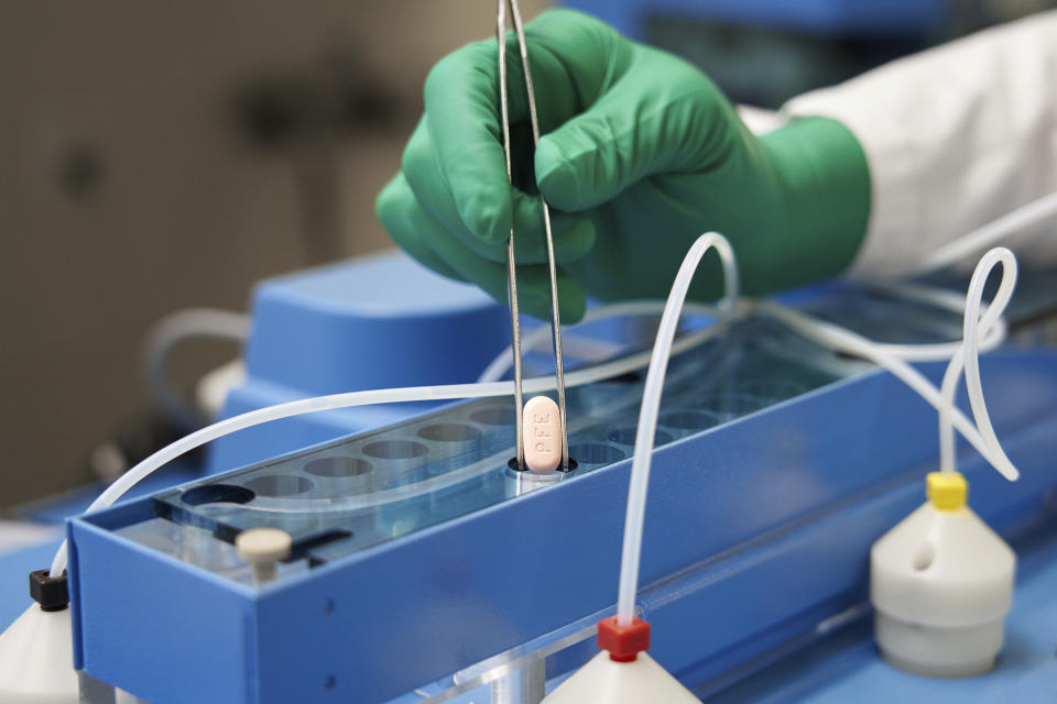 FILE - In this photo provided by Pfizer, a technician handles one of the company's COVID-19 Paxlovid pills. COVID-19 patients have two new treatment options that can be taken at home. But that convenience comes with a catch: The pills have to be taken as soon as possible once symptoms appear. U.S. regulators authorized the pills from Pfizer and Merck late 2021. (Pfizer via AP, File)