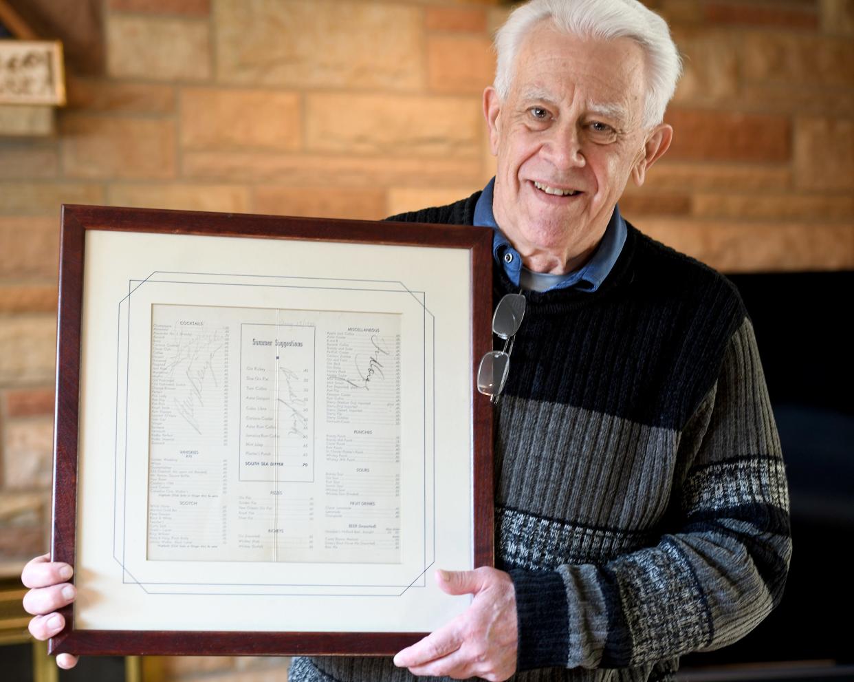 North Canton resident Joe Fraley holds the old Hotel Astor cocktail menu his father almost threw away. It has autographs of the band playing that night in 1940, including Tommy Dorsey, Buddy Rich and guest singer Frank Sinatra.