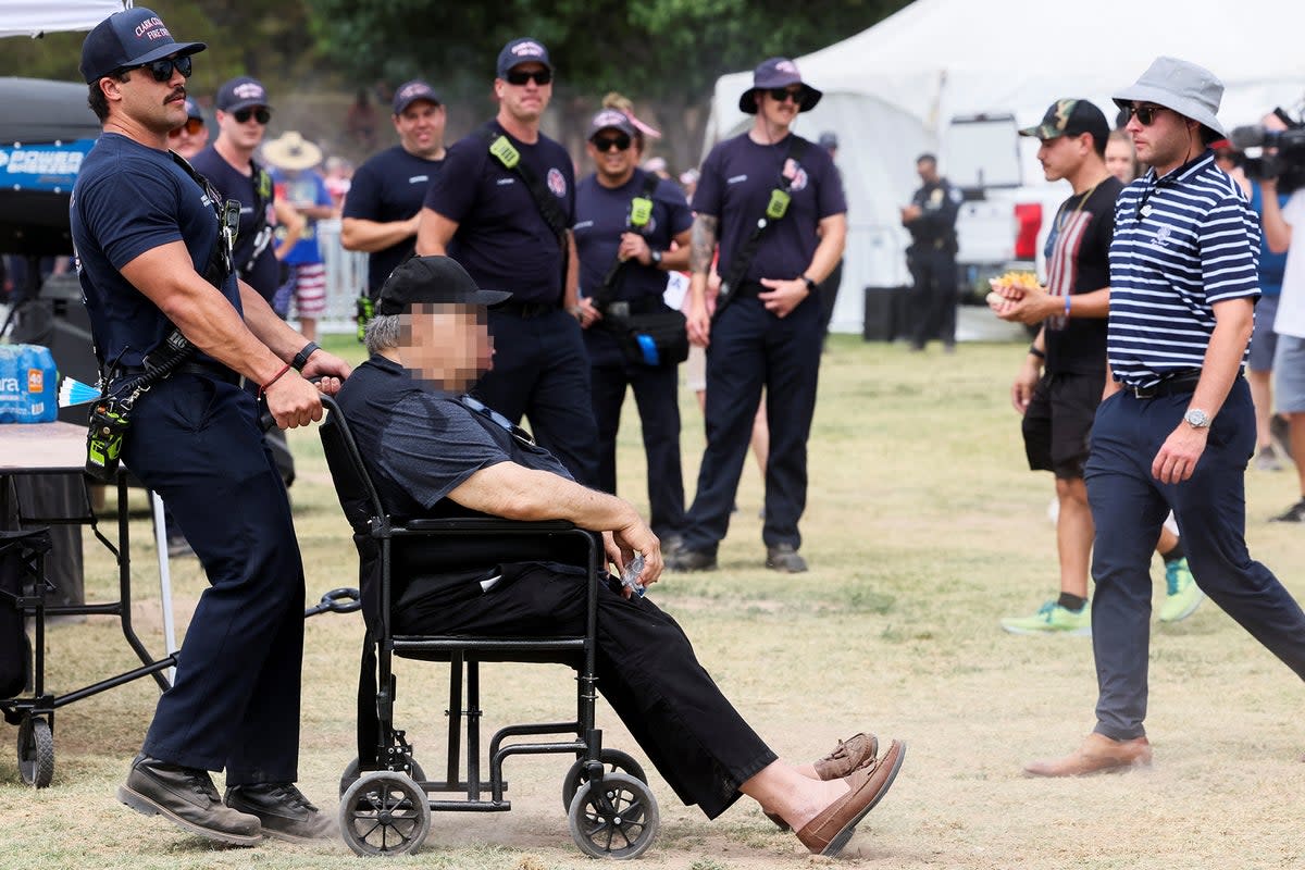 A man suffering from heat exhaustion receives aid from fire department at Trump’s Nevada rally (Reuters)