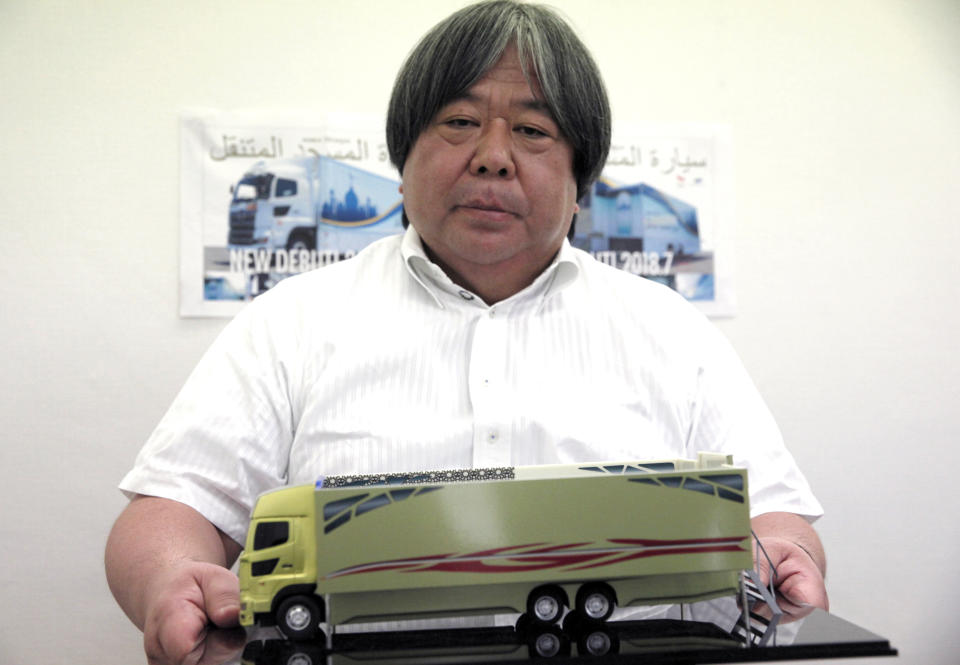 In this July 20, 2018, photo, Yasuharu Inoue, chairman of Mobile Mosque Executive Committee, shows off a scale model of Mobile Mosque, a mosque on wheels with the capacity for up to 50 people, in Tokyo. As Japan prepares to host visitors from around the world for the Summer Olympics in 2020, the Tokyo sports and cultural events company has created a mosque on wheels that its head hopes will make Muslim visitors feel at home. (AP Photo/Nicola Shannon)