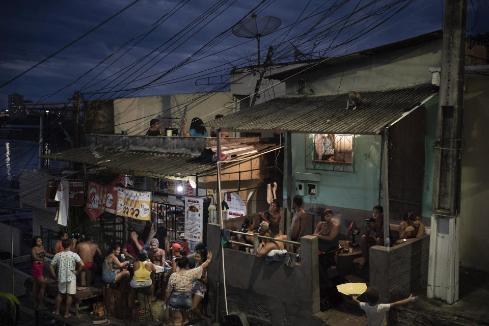 Varias personas se reúnen en un bar en una calle en Manaos, Brasil, el 24 de mayo de 2020, durante la pandemia del coronavirus. Aunque los expertos advierten que la pandemia está lejos de terminar en la región amazónica, o en el resto del país, encuestas nacionales revelan que la adherencia a las cuarentenas y a los confinamientos está bajando, y que un creciente número de brasileños ignora las recomendaciones de seguridad de los gobernantes locales. (AP Foto/Felipe Dana)