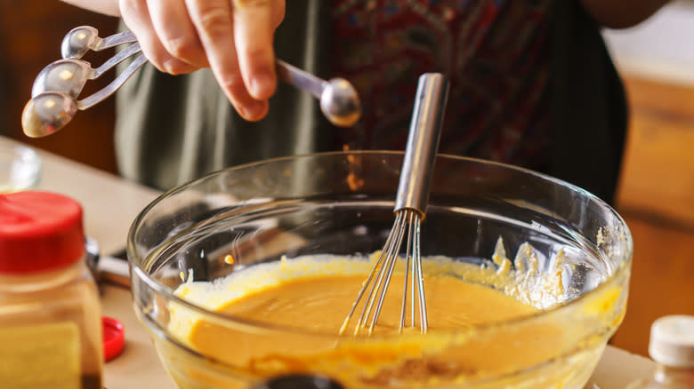 Measuring spoons over bowl of batter