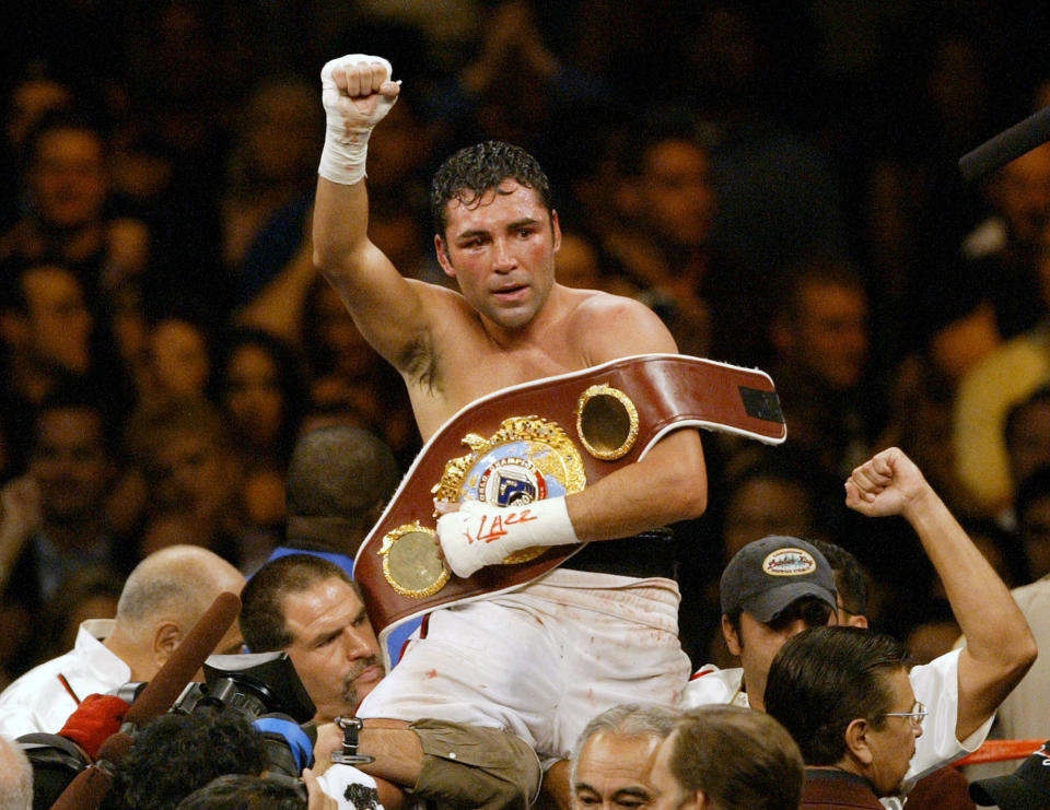 FILE - In this June 5, 2004 file photo, Oscar De La Hoya celebrates his unanimous decision victory over Germany&#39;s Felix Sturm following their WBO world middleweight title fight in Las Vegas. De La Hoya got drunk the night he won the only boxing gold for the U.S. in the 1992 Olympics, and was still drinking when he lost his last fight to Manny Pacquiao. Now sober after a second stint in rehab he’s in a fight of another kind for control of his boxing company. (AP Photo/Joe Cavaretta, File)