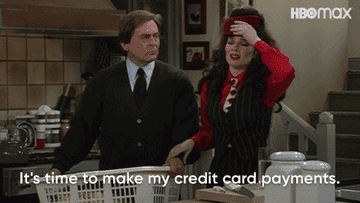 Two characters from a TV show in a comedic scene, one expressing concern about credit card payments