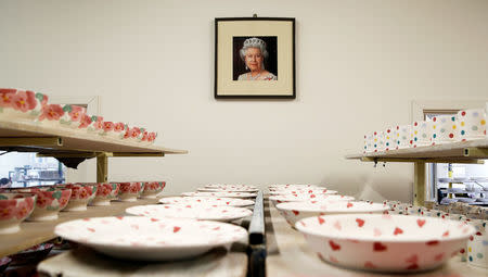 A portrait of Britain's Queen Elizabeth hangs in the Decorating Studio where mugs to commemorate the wedding of Britain's Prince Harry and Meghan Markle are being made at the Emma Bridgewater Factory, in Hanley, Stoke-on-Trent, Britain March 28, 2018. REUTERS/Carl Recine