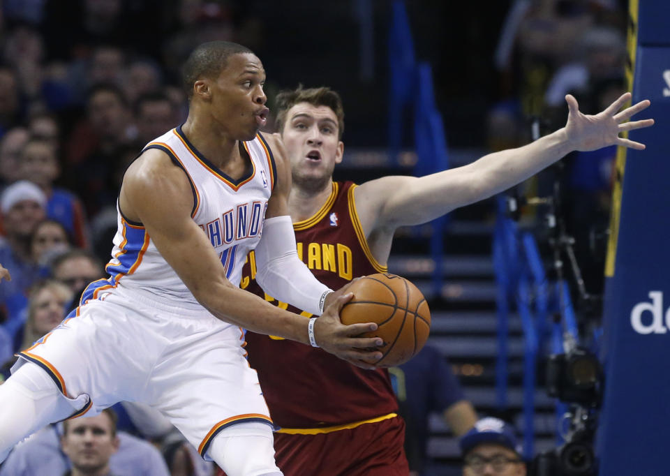 Oklahoma City Thunder guard Russell Westbrook (0) passes off in front of Cleveland Cavaliers center Spencer Hawes in the second quarter of an NBA basketball game in Oklahoma City, Wednesday, Feb. 26, 2014. (AP Photo/Sue Ogrocki)