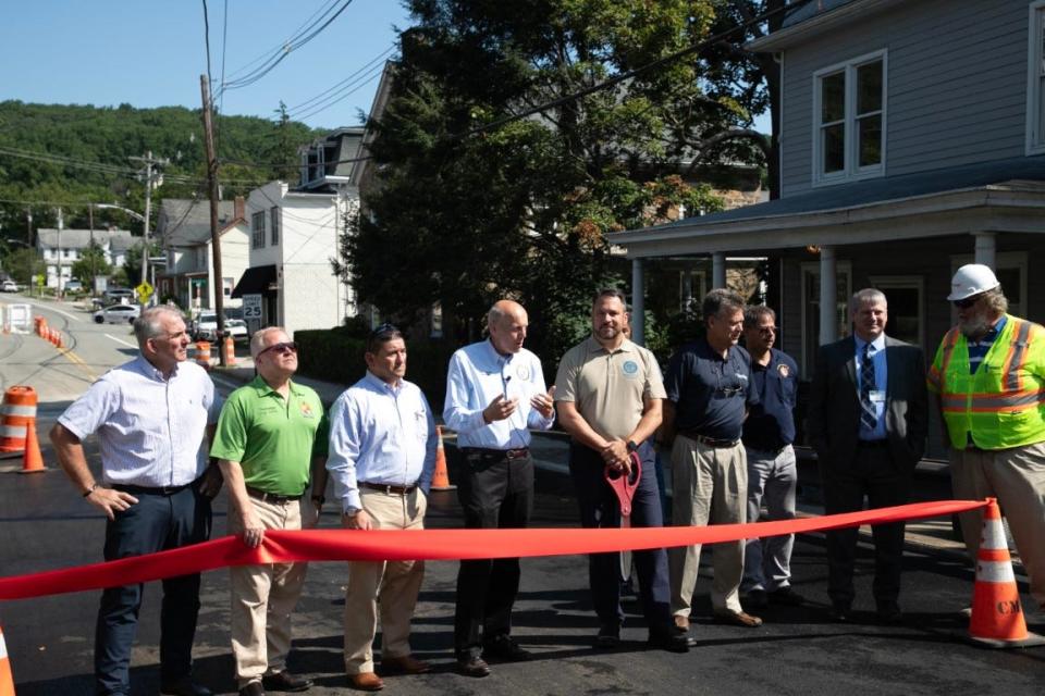 Morris County Commissioner Director John Krickus, fourth from left, and Washington Township Mayor Matt Murello, fifth from left, prepare to cut the ribbon marking the reopening of the Schooley's Mountain Road bridge Monday, July 31, 2023.