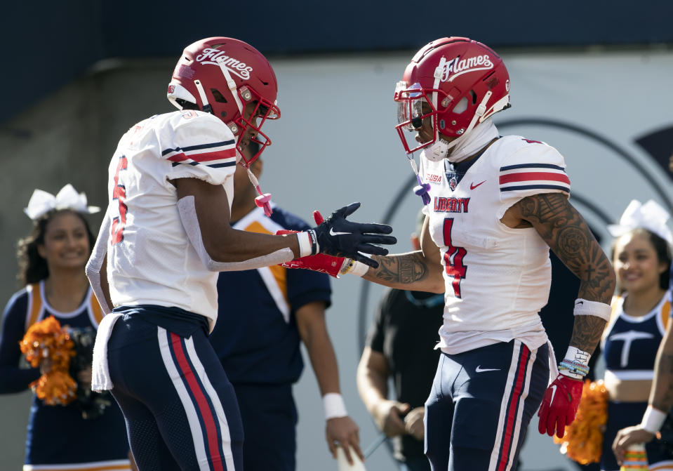 Liberty wide receiver CJ Daniels, right, is congratulated by wide receiver Noah Frith after scoring a touchdown against UTEP during the first half of an NCAA college football game on Saturday, Nov. 25, 2023, in El Paso, Texas. Liberty won 42-28. (AP Photo/Andres Leighton)