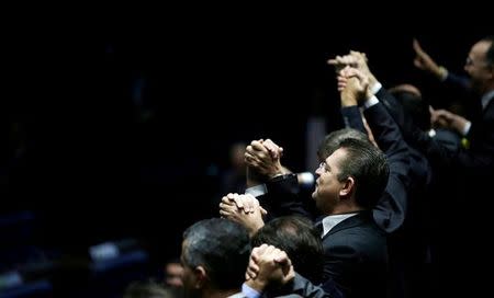 Members of Brazil's Senate react after a vote to impeach President Dilma Rousseff for breaking budget laws in Brasilia, Brazil, May 12, 2016. REUTERS/Ueslei Marcelino