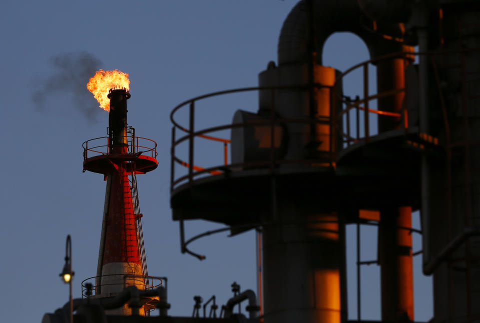 Oil  A flame shoots out of a chimney at a petro-industrial factory in Kawasaki near Tokyo December 18, 2014. Brent crude held steady above $61 a barrel on Thursday, bringing a sharp drop in prices to a temporary halt as companies are forced to cut upstream investments around the world. REUTERS/Thomas Peter (JAPAN - Tags: BUSINESS ENERGY)