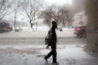FILE PHOTO: Man walks through falling snow, as seen through a frosted window, in New Haven, Connecticut