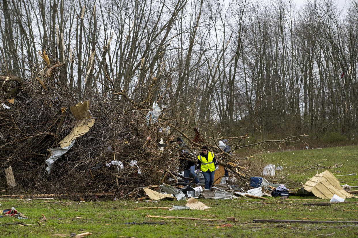 Volunteers comb through an area that was heavily damage by a tornado in Sullivan, Ind., Saturday, April 1, 2023, as search-and-rescue efforts continue. Storms that spawned possibly dozens of tornadoes have killed several people in the South and Midwest. (AP Photo/Doug McSchooler)