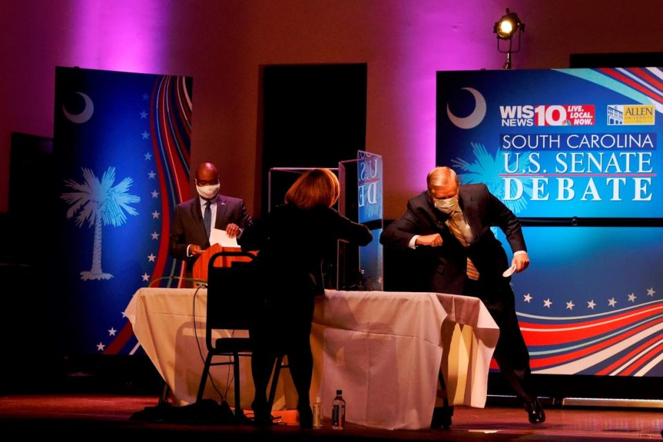 Sen. Lindsey Graham (right) and moderator Judi Gatson elbow bump after the first debate between Graham and Democratic challenger Jaime Harrison on  Oct. 3, 2020, in Columbia, S.C.  