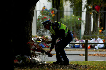 A policeman lays flowers outside of the Al Noor Mosque in Christchurch, New Zealand March 21, 2019. REUTERS/Edgar Su