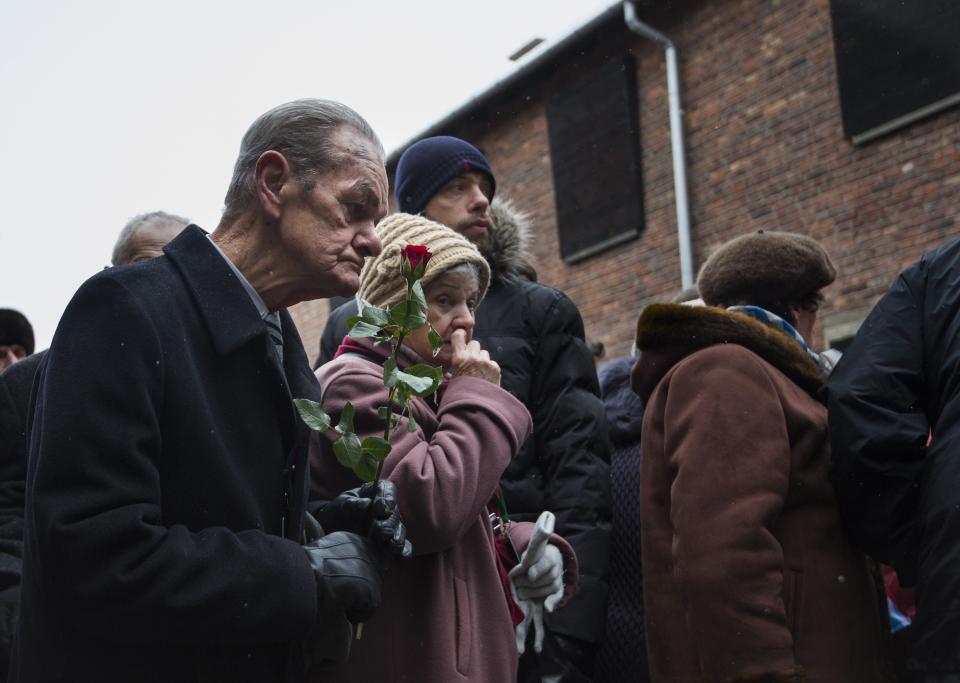 Holocaust survivors pay tribute to fallen comrades at the 'death wall' execution spot in the former Auschwitz concentration camp in Oswiecim, Poland, on the 70th anniversary of the liberation of the Nazi death camp on January 27, 2015. Seventy years after the liberation of Auschwitz, ageing survivors and dignitaries gather at the site synonymous with the Holocaust to honour victims and sound the alarm over a fresh wave of anti-Semitism.