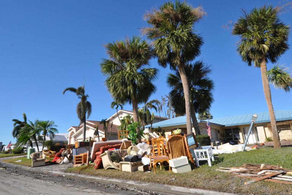 Contents of a home in Coco Bay neighborhood are moved out on Sunday, Oct. 2, after facing 8-10 feet of water from storm surge in Fort Myers, Fla.