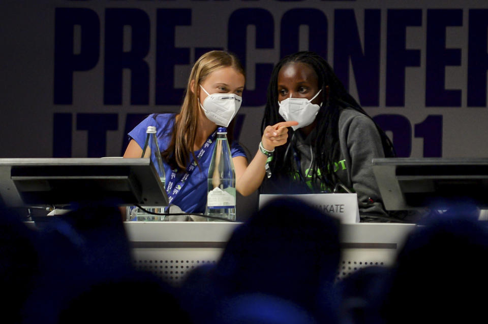 Swedish climate activist Greta Thunberg, left, and Ugandan climate activist Vanessa Nakate share a word as they attend the start of a three-day Youth for Climate summit in Milan, Italy, Tuesday, Sept. 28, 2021. (Claudio Furlan/LaPresse via AP)