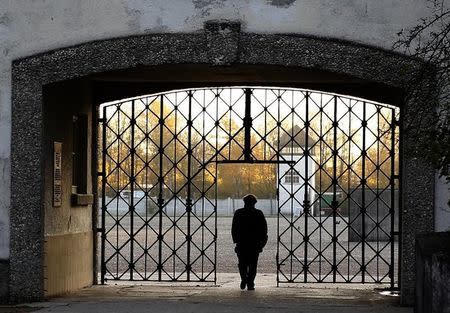 A woman walks through the main gate of the former concentration camp in Dachau near Munich where the door with the Nazi slogan "Arbeit macht frei" (Work sets you free) has been stolen November 3, 2014. REUTERS/Michael Dalder