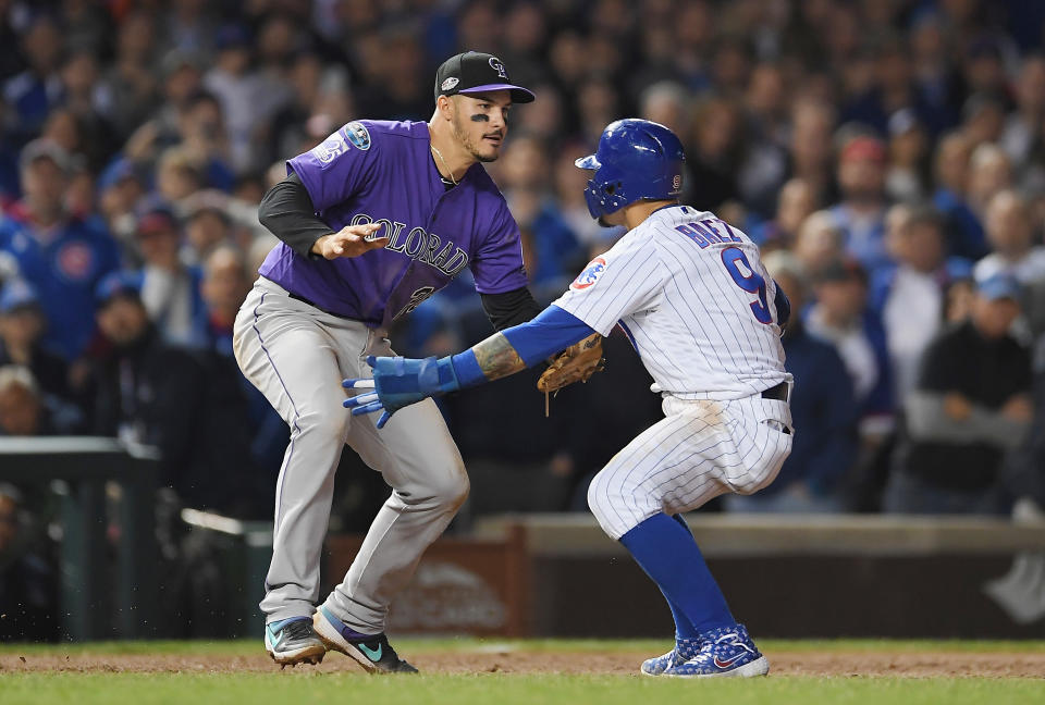 Nolan Arenado tries tag Javier Baez before they hug during the NL wild-card game. (Getty Images)