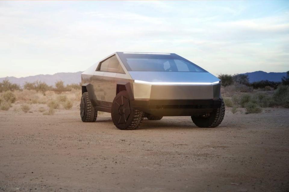 A Tesla Cybertruck parked in a desert landscape.