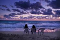 <p>Zwei Frauen sitzen an der Nordküste von Matruh, Ägypten und schauen sich den Sonnenaufgang an. (Bild: Nariman El-Mofty/AP/dpa) </p>