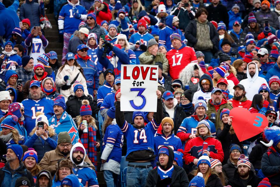 Fans hold signs in support of safety Damar Hamlin before an NFL football game against the New England Patriots on Sunday in Orchard Park, N.Y.