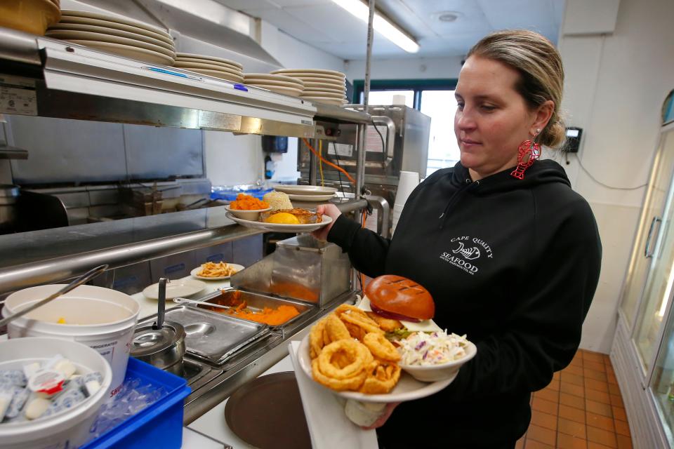 Joyelle Benevides, manager, brings out a lunch order at Cape Quality Seafood on Dartmouth Street in Dartmouth.