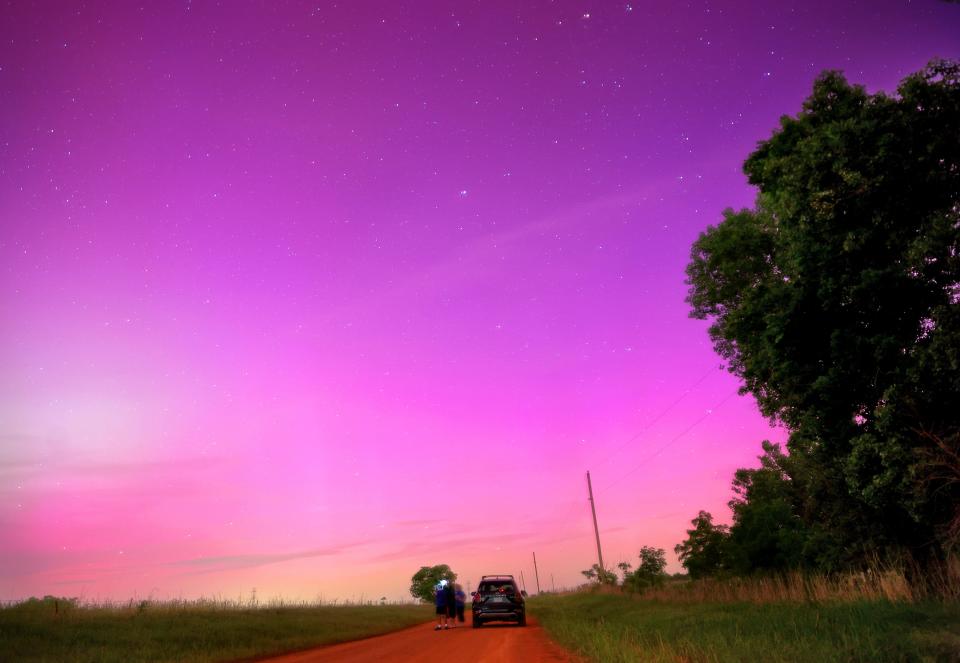 People look at the Northern lights near Cashion, Okla., Friday, May, 10, 2024.
