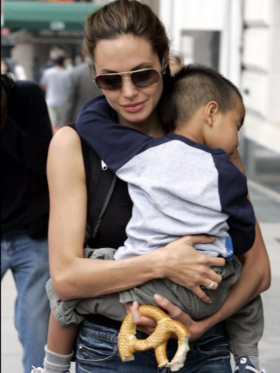 Angelina carrying a very tiny Maddox when he was younger. Source: Getty