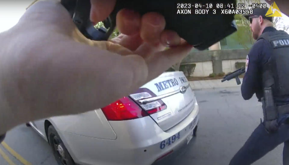 This screen grab taken from the body cam video of Louisville Metro Police Department Officer Nickolas Wilt, left foreground, shows Officer Cory Galloway, right, with his weapon drawn as the two officers approach an active shooting situation at Old National Bank, in Louisville, Ky., Monday, April 10, 2023. (Louisville Metro Police Department via AP)