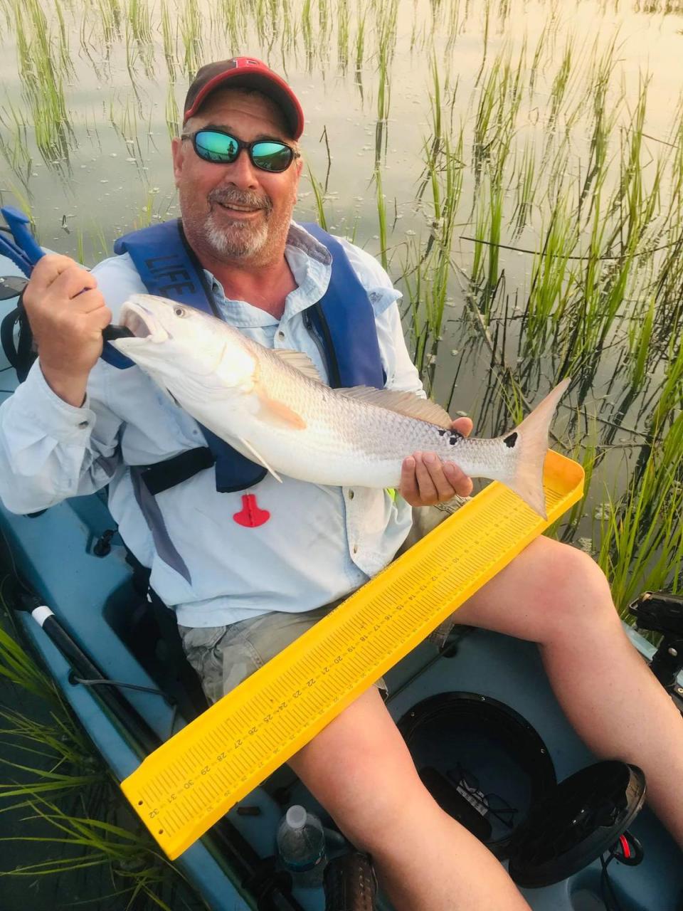 Angler Greg Lippincott shows off a 28 ½-inch redfish from a kayak before releasing it Friday morning. Lippincott was fishing with Capt. Rob Birchmeier of Pawleys Island Beach to Creek Guide Service and Black River Outdoors