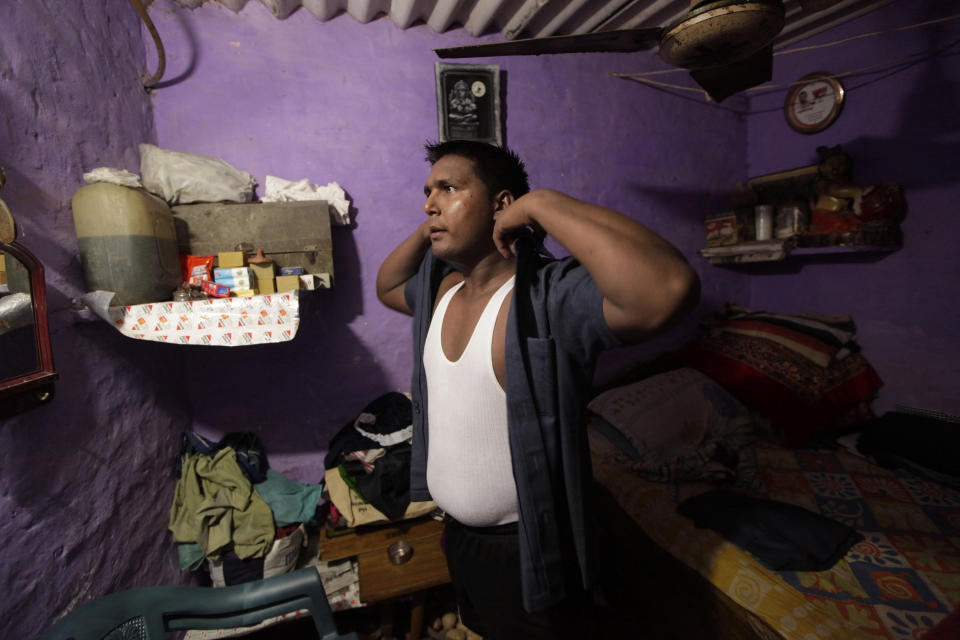 n this Monday, Aug. 20, 2012 photo, Pradeep Kumar puts on his security guard uniform as he gets ready to go to work at the Deen Dayal Upadhyay Hospital in New Delhi, India. Kumar and 20 other bouncers have been hired to protect doctors as well as keep the emergency and labor rooms from filling up with patients’ often agitated relatives and friends. (AP Photo/Manish Swarup)