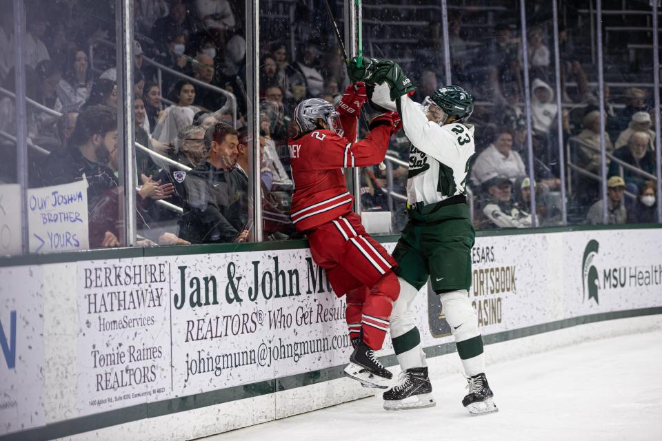 Michigan State forward Jagger Joshua lays a hit along the boards on Ohio State defenseman James Marooney on November 10, 2022 at Munn Ice Arena. MSU defeated the Buckeyes, 4-2