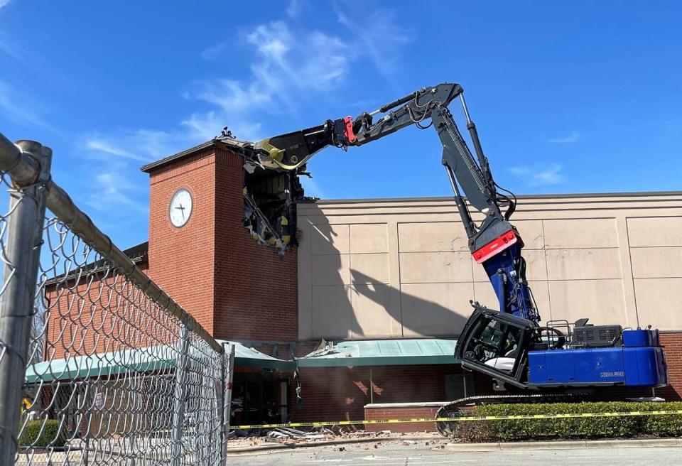 An excavator tears into the clock tower that for many years stood at the corner of the A Southern Season store at University Place mall on Estes Drive in Chapel Hill. It will take about two months to demolish the eastern end of the mall, Ram Realty officials said.