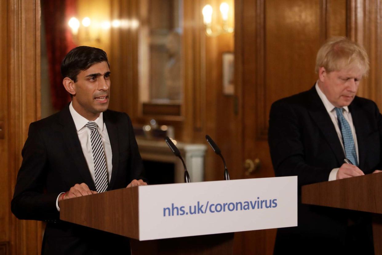 Chancellor Rishi Sunak, left, is flanked by British Prime Minister Boris Johnson: AP
