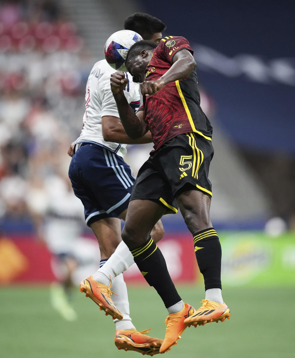Seattle Sounders' Nouhou Tolo, right, and Vancouver Whitecaps' Mathias Laborda vie for the ball during the second half of an MLS soccer match Saturday, July 8, 2023, in Vancouver, British Columbia. (Darryl Dyck/The Canadian Press via AP)