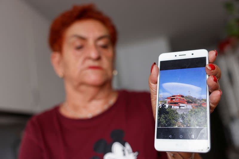 Paez, 73, in her container house delivered by the government, shows on her mobile a photograph of the house she lost to the Tajogaite volcano