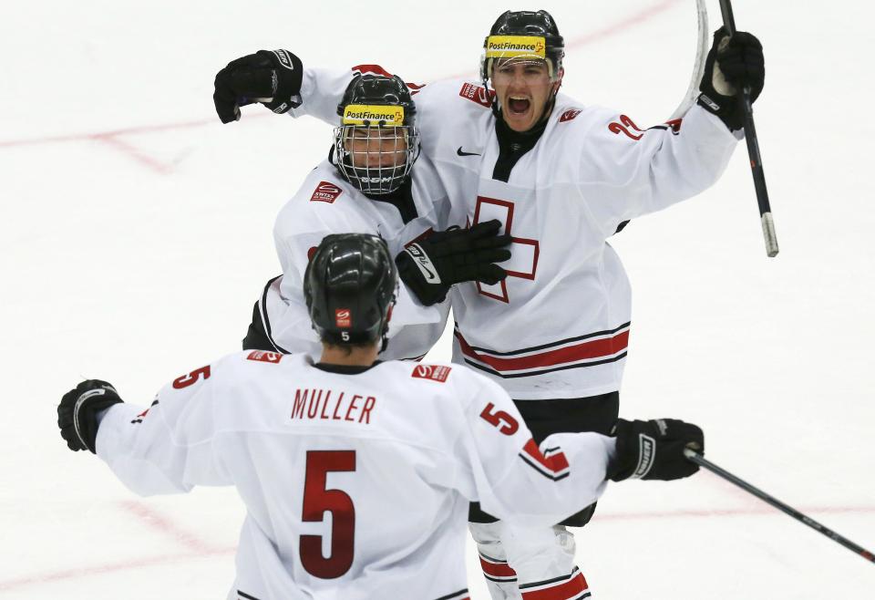 Switzerland's Dunner celebrates his goal against Canada with teammate Fiala and Muller during the second period of their IIHF World Junior Championship ice hockey game in Malmo