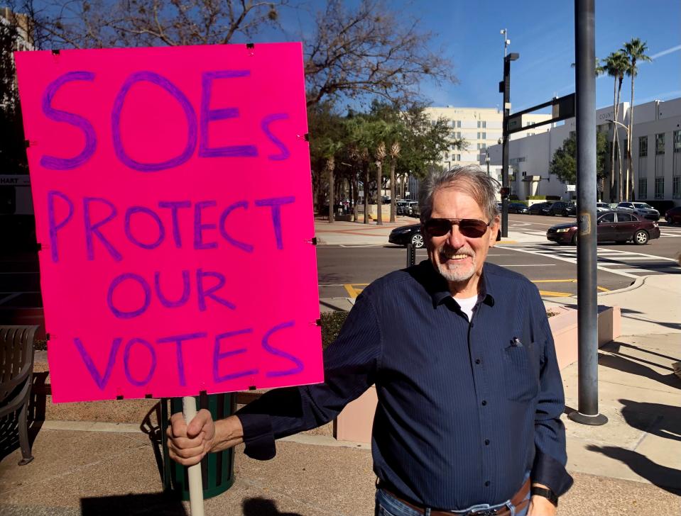 Defend Florida canvasser Hans Theerman of Bradenton holds a sign at a rally in Tampa on Thursday. Defend Florida has been investigating alleged “voting irregularities” in Florida and advocating for changes to election law based on their findings, but elections officials have dismissed their claims.