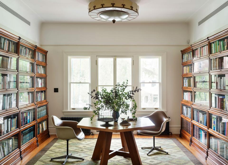 Lined with barrister bookshelves, the stair hall’s second-story landing doubles as a workspace.