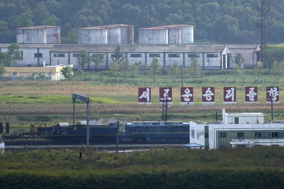 Un tren verde con destellos en amarillo, similar al que utilizó el gobernante norcoreano Kim Jong Un en sus viajes previos, pasa frente a un letrero con la leyenda "Hacia una nueva victoria", en la frontera de Corea del Norte con Rusia y China, desde la plataforma panorámica Tres Reinos de Yiyanwang, el lunes 11 de septiembre de 2023, en Fangchuan, en la provincia de Jilin, en el noreste de China. (AP Foto/Ng Han Guan)