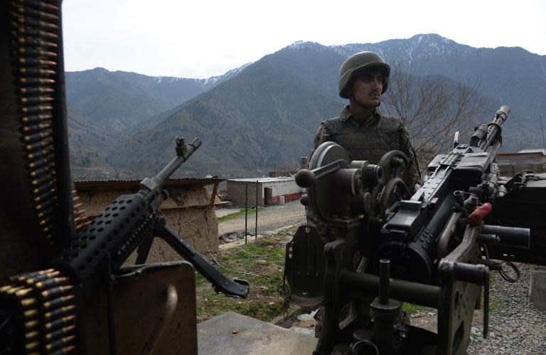 An Afghan soldier stands guard at a border checkpoint in Kunar province, on the border with Pakistan, on February 24, 2014