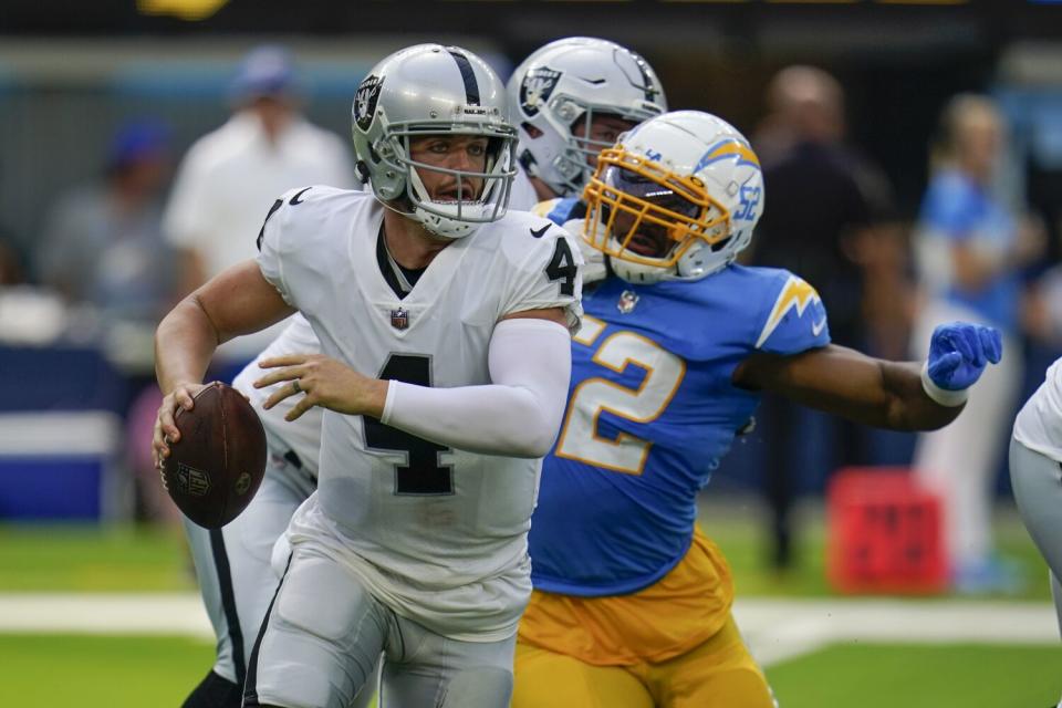 Las Vegas Raiders quarterback Derek Carr is chased by Chargers linebacker Khalil Mack.