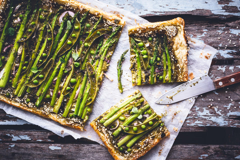 Asparagus tastes delicious on a simple ready-roll puff pastry tart with peas, pesto and cheese. (Getty Images)