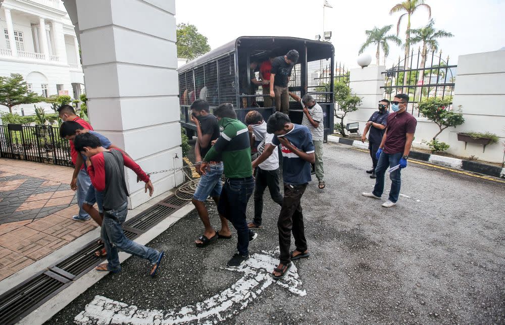 Police round up detainees who flouted the movement control order at the Ipoh Magistrate’s Court April 2, 2020. — Picture by Farhan Najib