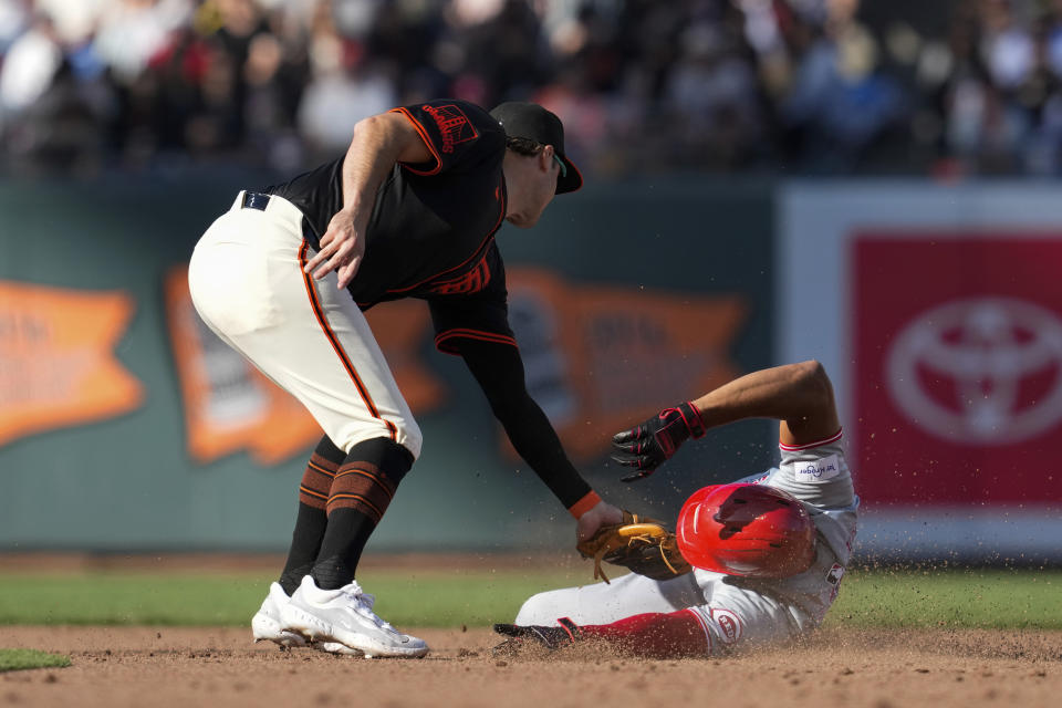 San Francisco Giants shortstop Casey Schmitt, left, tags out Cincinnati Reds' Jeimer Candelario at second base during the sixth inning of a baseball game Saturday, May 11, 2024, in San Francisco. Candelario singled before trying to extend it to a double. (AP Photo/Godofredo A. Vásquez)