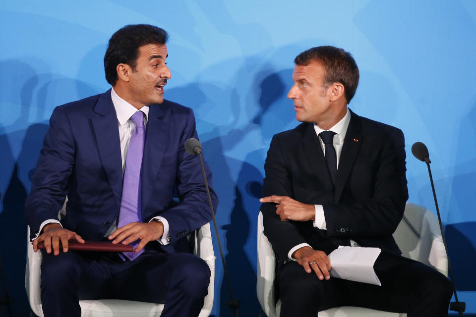 France's President Emmanuel Macron, right, talks with Qatar's Emir Sheikh Tamim bin Hamad Al-Thani before addressing the Climate Action Summit in the United Nations General Assembly, at U.N. headquarters, Monday, Sept. 23, 2019. (AP Photo/Jason DeCrow)