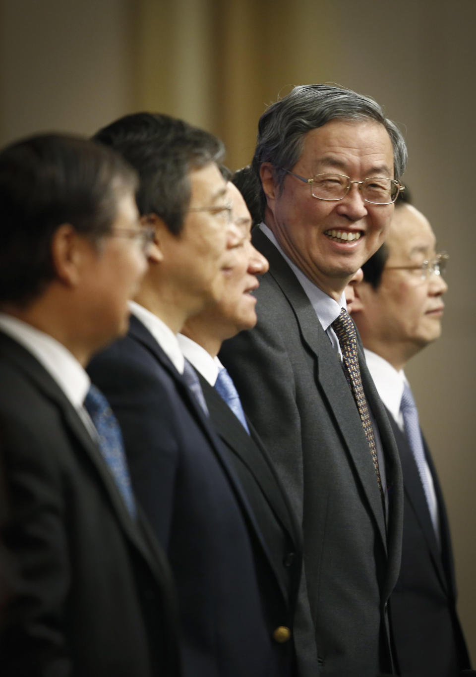 People's Bank of China governor Zhou Xiaochuan, second from right, smiles as he pose for photographers before a press conference held during the National People's Congress at the media center in Beijing, China, Tuesday, March 11, 2014. Zhou said Beijing might finish the process of easing controls on interest rates within two years and market forces will set the pace for allowing use of its tightly controlled currency abroad. (AP Photo/Vincent Thian)