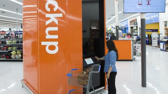 A customer entering information into a pickup tower at Wal-Mart.