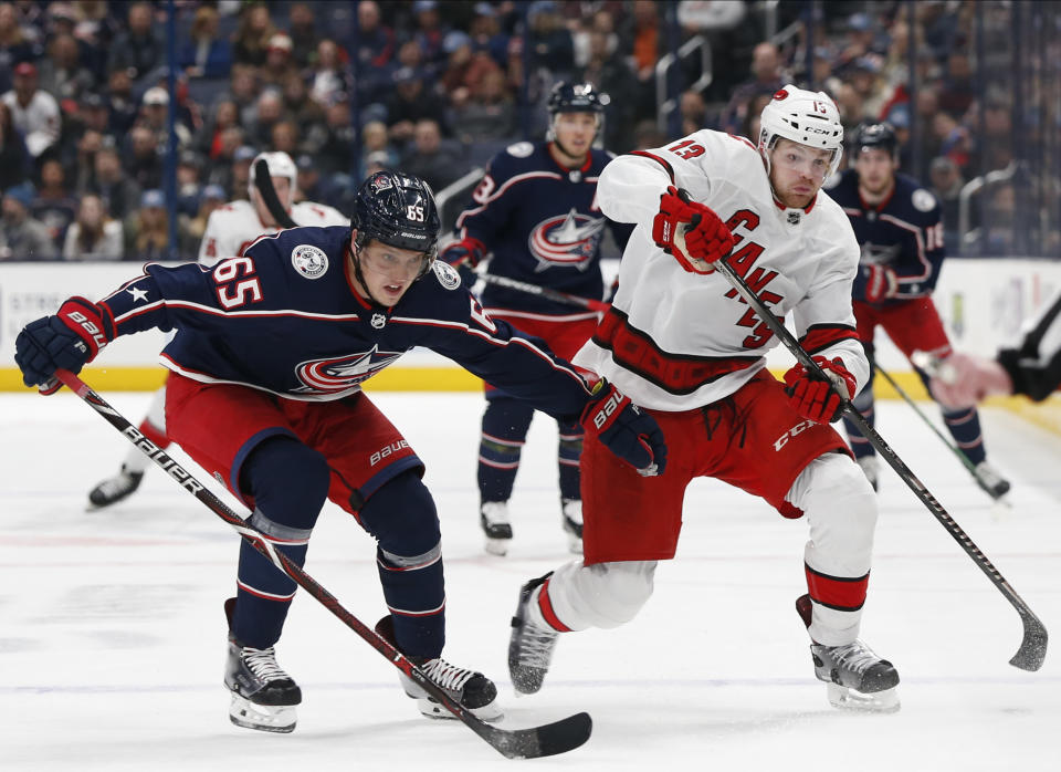 Columbus Blue Jackets' Markus Nutivaara, left, of Finland, and Carolina Hurricanes' Warren Foegele chase the puck during the first period of an NHL hockey game Thursday, Jan. 16, 2020, in Columbus, Ohio. (AP Photo/Jay LaPrete)